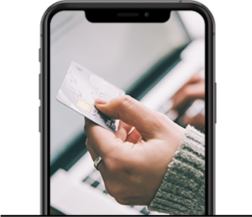 Cell phone showing a hand holding a credit card during an online payment transaction.